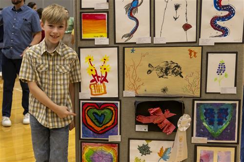 Elementary student with their artwork